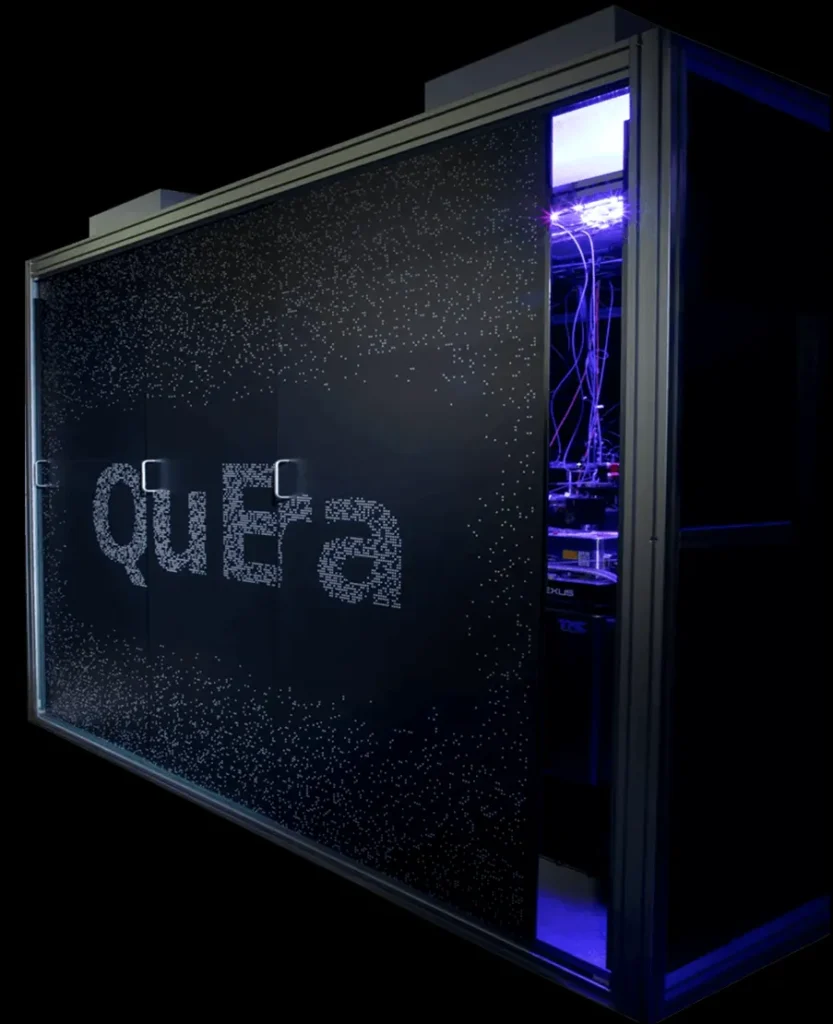 A large black quantum computer cabinet with 'quaEra' text made of small dots on the front panel and visible internal blue-lit cables and components.
