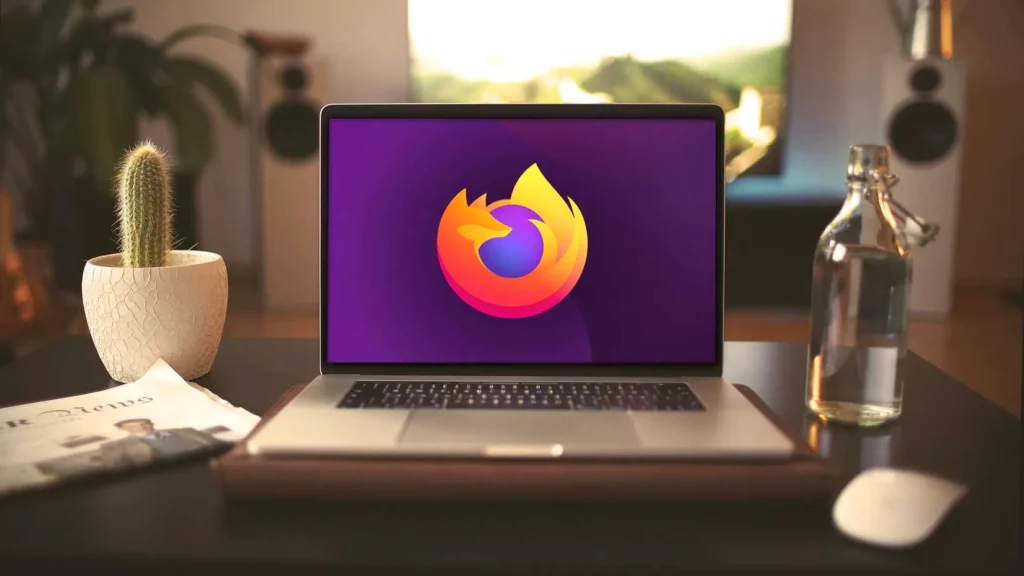 A MacBook Pro laptop with a Mozilla Firefox logo on the screen