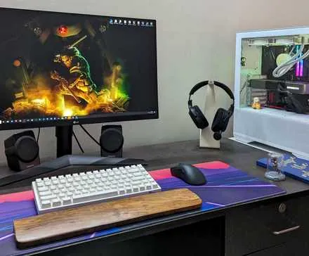 A desktop PC setup with a large mouse pad, keyboard, mouse and headphone on the desk
