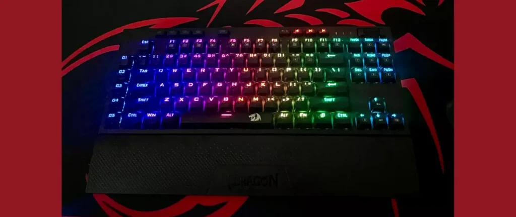 black compact keyboard with wrist rest against black and red background