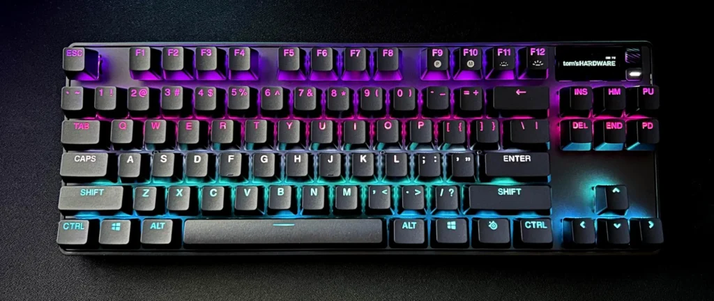 black compact keyboard with multi-color lighting against black background